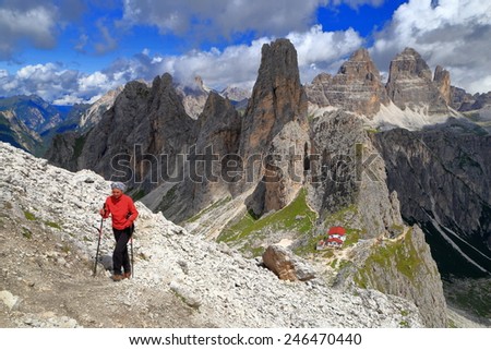 Woman climbs a rocky trail above in Cadini di Misurina, Dolomite Alps, Italy