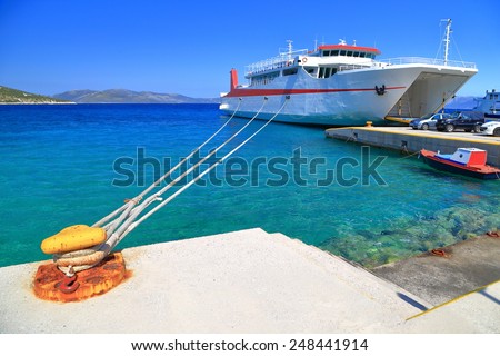 Large anchor keeps ferry boat aligned to the shore inside the harbor of Agia Marina, Greece