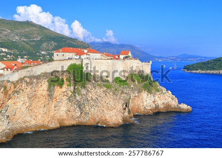 Sunny walls of Dubrovnik old town surrounded by the waters of the Adriatic sea, Croatia