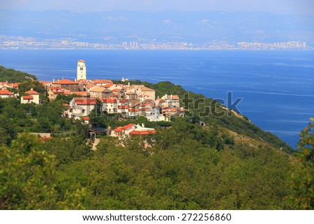 Church and houses of traditional town above the Adriatic sea, Croatia