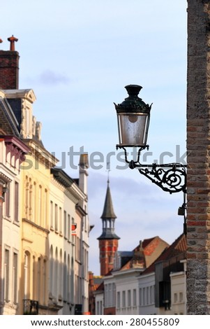 Isolated street lamp on a wall inside Bruges old town, Belgium