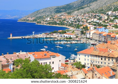 Old harbor with traditional buildings surrounding a sunny bay in Senj, Croatia