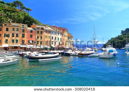 Colorful facades of old buildings and luxury boats inside the harbor of Portofino, Italy