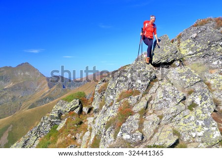 Woman hiker traversing a rocky trail on top of the mountain