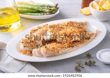 A plate of delicious panko breadcrumb crusted baked haddock with asparagus and lemon. Stockfoto © 