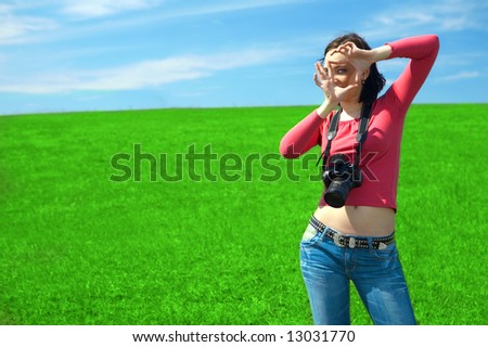 woman photographer in field under blue sky and clouds