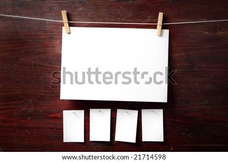 Photo paper attach to rope with clothes pins on wooden background