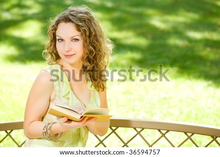 Beauty woman reading a book in park