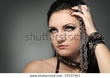 young naked woman in chain on black background