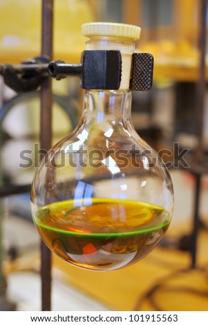 Round laboratory flask with brown liquid (shallow DoF)