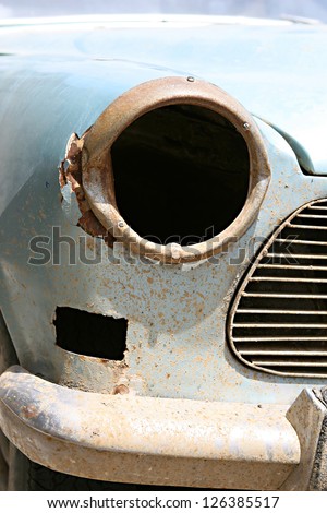 An old blue car in need of repairs