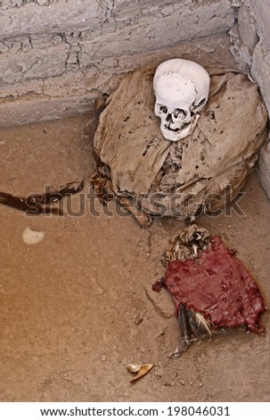 This pre-incan mummy is preserved by the dry desert air with hair intact. Skulls and bones in Chauchilla, an ancient cemetery in the desert of Nazca, Peru.