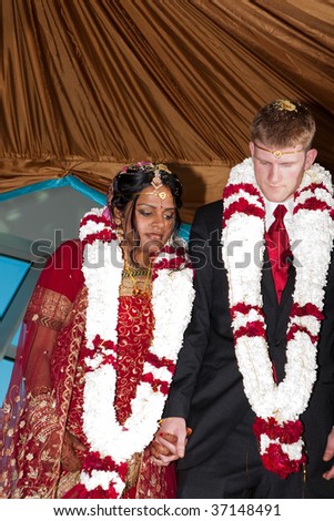 A bride and groom perform a series of steps as part of a traditional Hindu wedding ceremony