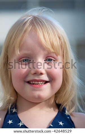 A young girl with beautiful blue eyes smiling