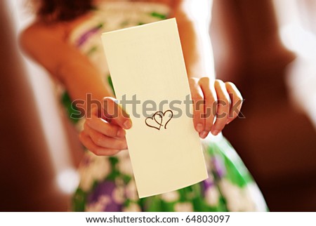 A young girl holds a blank wedding program. Add your own text.