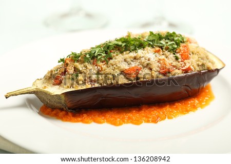 Closeup stuffed eggplant  with cheese and tomato on white plate