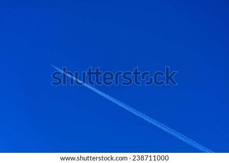 A plane flying on a perfectly blue sky with Vapor Trail