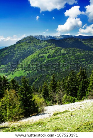 Mountains landscape with green grass, trees and clouds. Alps in eastern France