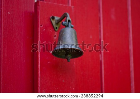 Small bell on the old red door