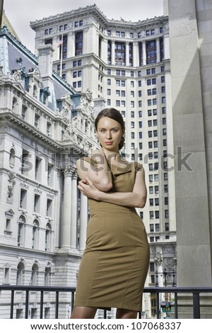 Dressing formally a serious business woman is standing in the front of a business district/Portrait of a professional woman