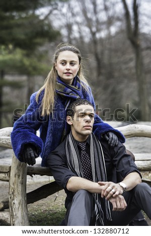 A young couple is sitting outside and passionately looking forward.