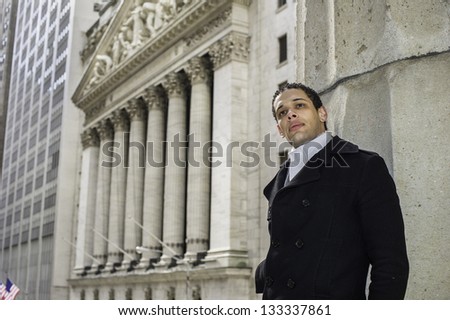 A young college student is standing outside of a business district and looking forward./Portrait of Young College Student