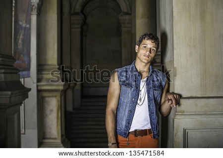Standing at a dark hallway, a young guy is thoughtfully looking at you/Portrait of  Young Guy
