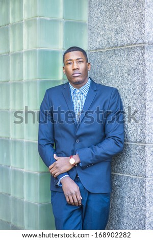 A young handsome black guy is standing in the corner between two walls,  thinking. / Thinking Outside