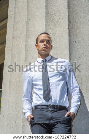 Businessman Thinking Outside. Dressing in a white shirt, a black tie, frowned, a young handsome guy is standing outside a office building, lost in thought.