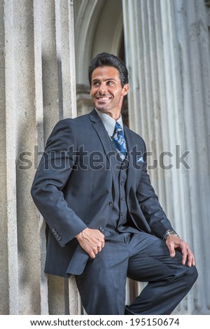 Man waiting for you. Dressing in dark blue suit, necktie, a handsome, sexy, middle age businessman is standing outside office, smiling, relaxing.