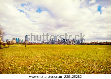 Cloudy Sky Over Jersey City and New York City in Autumn Season. Looking faraway, the left side is Jersey City and the right side is New York City. The front ground is Liberty State Park, New Jersey.