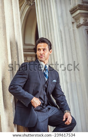 Way to Success. Dressing in dark blue three piece suit, necktie, a handsome, sexy, middle age businessman is standing against column outside office, confidently looking forward. Man Formal Fashion