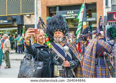 NEW YORK CITY - MARCH 17:  A young blonde girl taking pictures of her self with an old handsome man dressing in Irish costume on March 17, 2015, before St Patrick's Day Parade in Manhattan, New York.