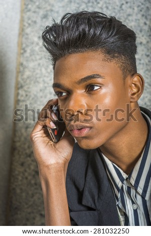 Portrait of School boy.  A young 18 years old black American college student, making phone call on his mobile phone. Technology in our daily life.