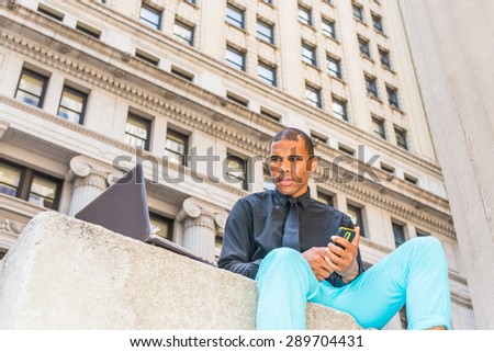 African American businessman with scar on his head, working on laptop computer, texting on phone in New York, Concept of facing reality, up and down, self assured, self esteem, confidence and success.