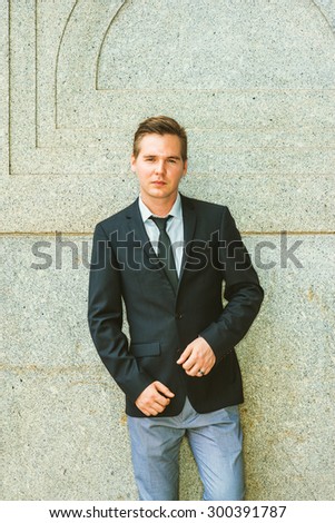 Portrait of Businessman. Dressing in black suit, tie, gray pants, a young professional standing against vintage style of wall, looking at you, confident, believing and success. Instagram effect.