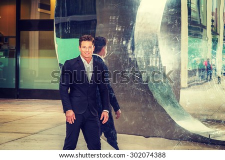 Portrait of Successful American Businessman. Dressing in black suit, a young, strong, sexy guy standing by metal mirror wall, smiling, confidently looking forward. Instagram filtered effect.