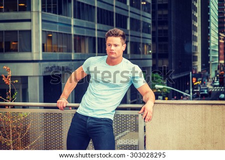 Hot American worker thinking in raining day, grainy, foggy, drizzly background. Wearing white T shirt, a young sexy guy standing on balcony in New York, inclining body, relaxing, thinking.