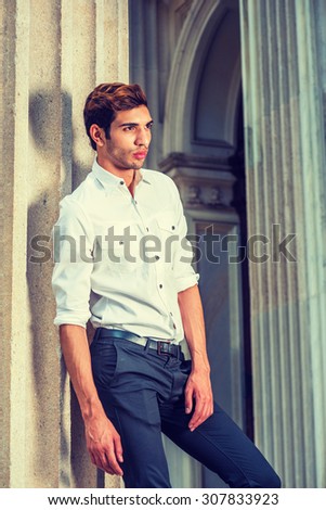 Businessman Working in New York. Wearing white shirt, black pants, sleeves rolling over, a young college student  standing outside office building, thinking, lost in thought. Instagram filtered look.