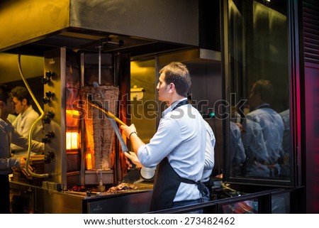ISTANBUL, TURKEY - APRIL 30, 2014: A chef cutting traditional Turkish food Doner Kebab in the restaurant on April 30, 2014 in Istanbul, Turkey.