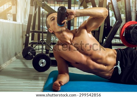 Man drinking protein shake mix while doing side plank exercise.