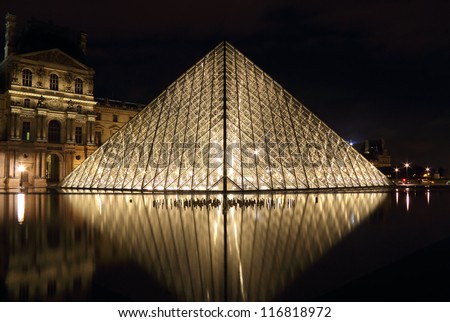 PARIS - OCTOBER 11 : View of the Louvre Pyramid reflected in water at night, October 11, 2012, Paris, France. The pyramid weight is about 180 tons