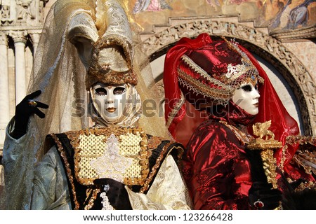 VENICE - FEBRUARY 17: Masks couple with San Marco church paintings during Carnival on February 17 , 2012 in Venice , Italy . In 1979, a group of Venetians decided to revive the tradition of Carnivals