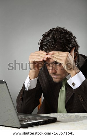 Worried gesture and expression of a businessman in front of portable computer