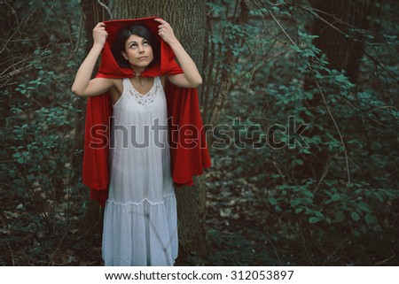 Little red riding hood alone in dark forest before the storm. Fantasy and fairy tale