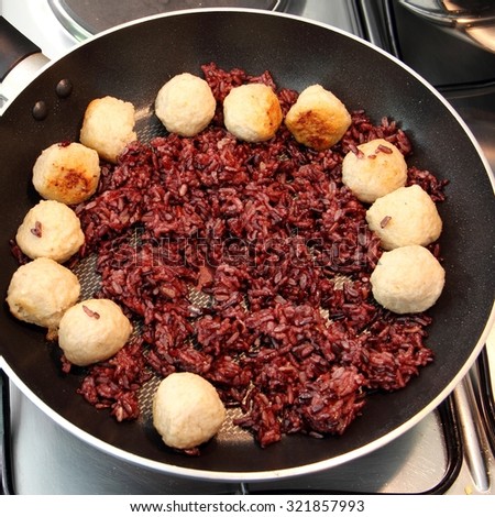 riceberry rice cooking wiht shrimp ball in the hot pan on stove  square format