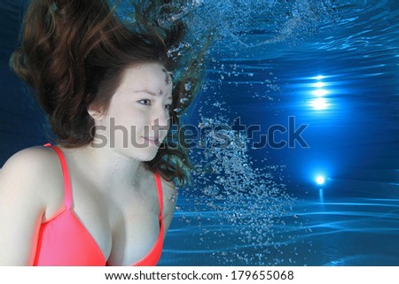 Woman underwater in the pool with air bubbles