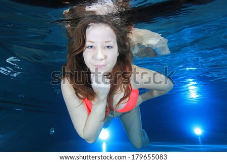 Woman smiling underwater in the pool