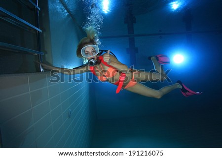 Female scuba diver show signal underwater in the pool