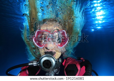 Portrait of female scuba diver underwater with bubbles